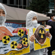 Environmental activists wearing a mask of Japanese Prime Minister Yoshihide Suga and protective suits protest the government’s decision in Seoul, South Korea.